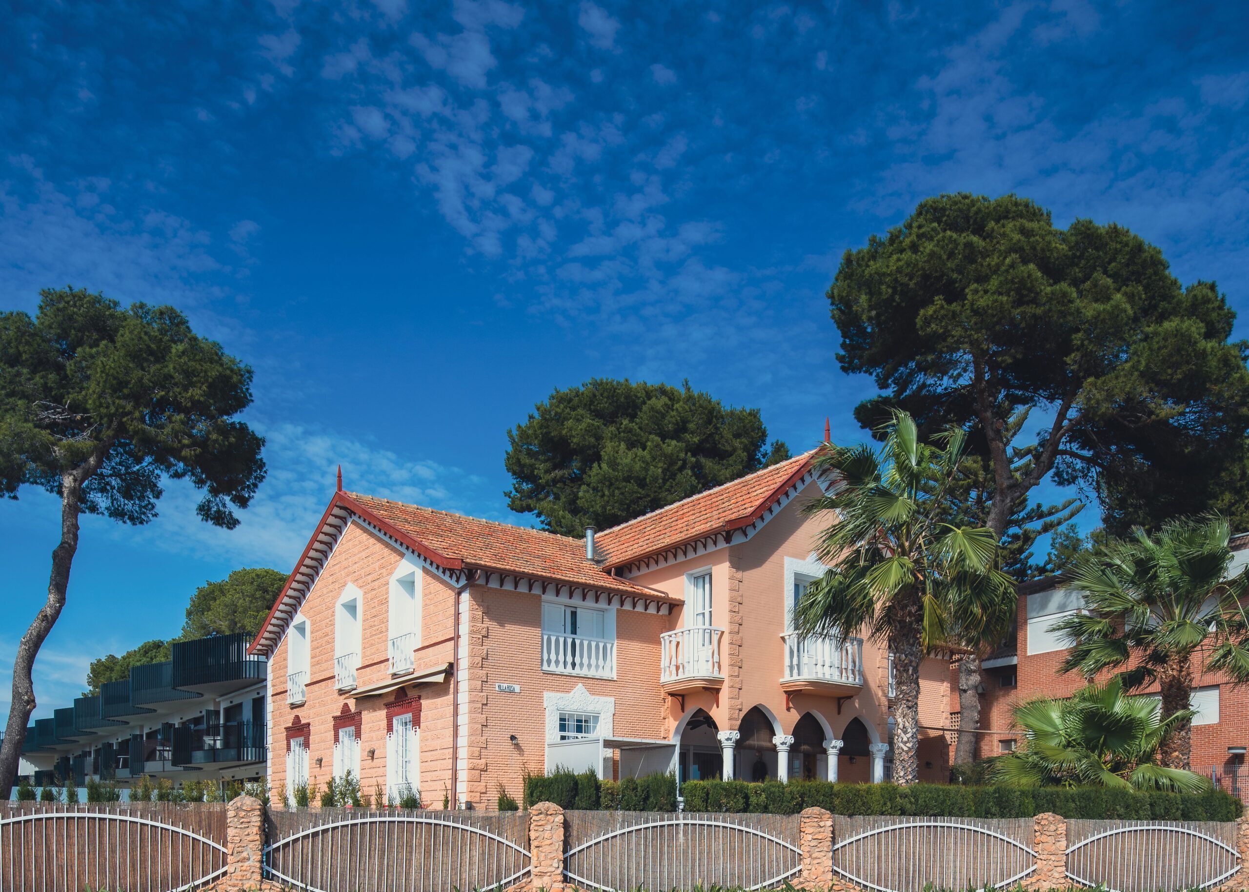 Picturesque villa in San Javier, Spain surrounded by lush trees and vibrant blue sky, ideal for travel enthusiasts.