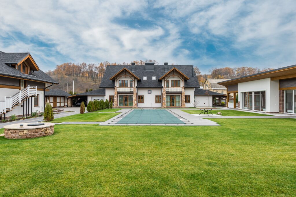 Exterior of contemporary residential cottage house with green lawn in yard under cloudy sky